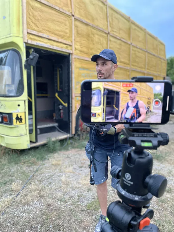 Tournage d’un reel Instagram de Kom1pro devant un bus en travaux